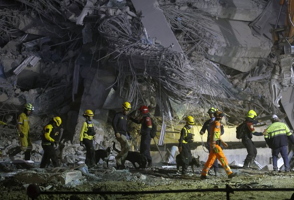 epa11997136 Rescue workers and dogs carry out a search operation at the site of a building that collapsed following an earthquake in Bangkok, Thailand, 29 March 2025. According to Suriyachai Rawiwan,  ...