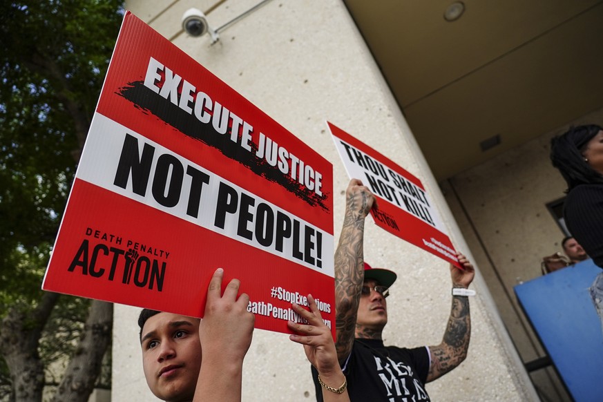 Nathan Hernandez Jr. and his father Nathan Hernandez Sr. hold up signs in support Wednesday, April 27, 2022, at a rally to urge Cameron County District Attorney Luis V. Saenz to release Melissa Lucio  ...