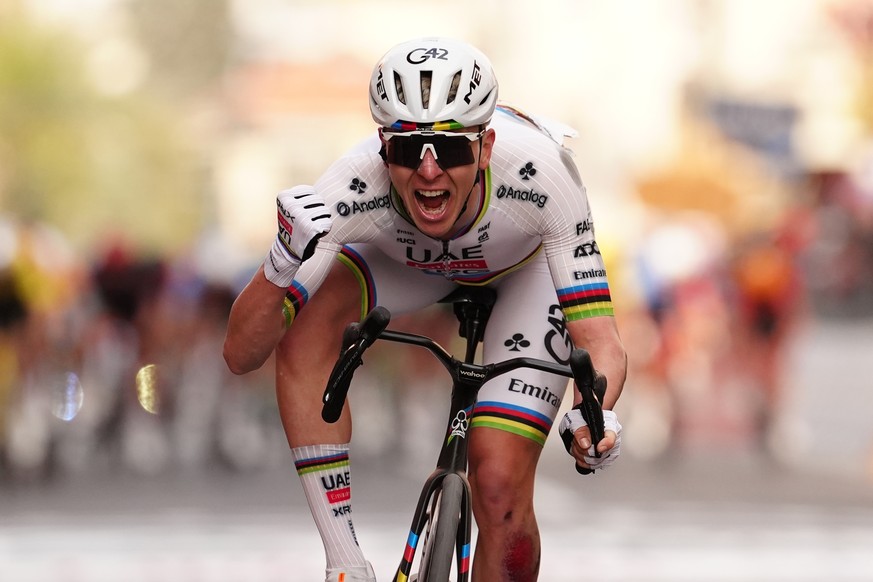 Slovenia's Tadej Pogacar of UAE Team Emirates XRG celebrates after crossing the finish line ahead of Britain's Thomas Pidcock of Pinarello-Q36.5 Pro Cycling Team to win the men's elite  ...
