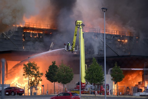 Des pompiers luttent contre les flammes lors de l'incendie d'un entrepot du centre d'assainissement et de revalorisation ECOSOR ce jeudi 30 juillet 2026 dans la zone industrielle du Mou ...