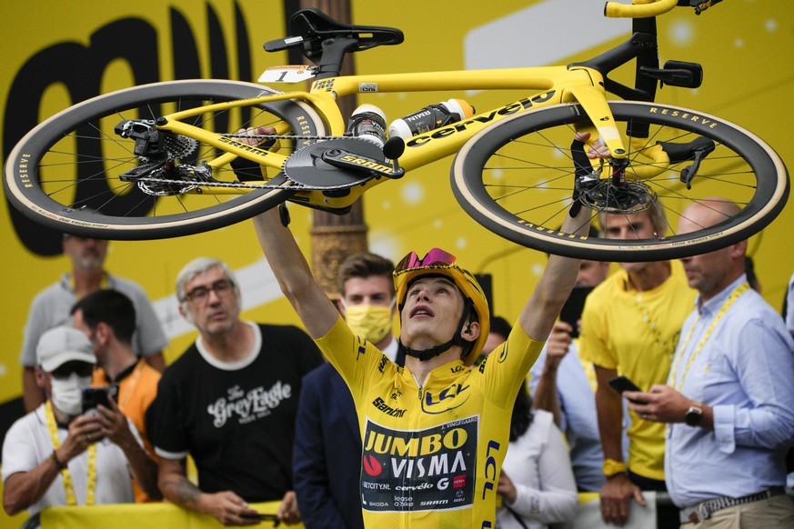 Tour de France winner Denmark&#039;s Jonas Vingegaard, wearing the overall leader&#039;s yellow jersey, lifts his bicycle after the twenty-first stage of the Tour de France cycling race over 115 kilom ...