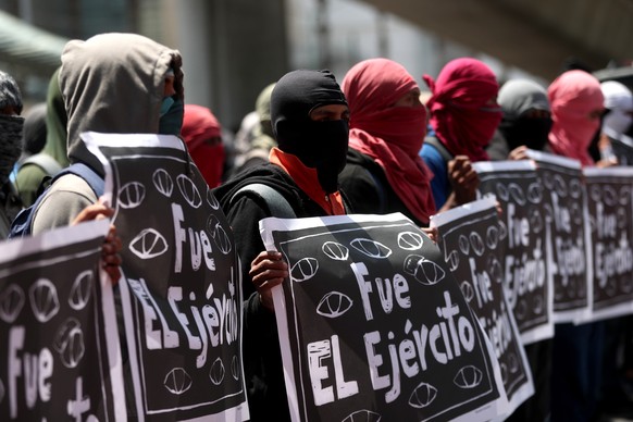 epa10202603 Demonstrators hold signs reading 'It was the army' during a protest for the 43 disappeared students of Ayotzinapa, in Mexico City, Mexico, 23 September 2022. The demonstrators marched on M ...