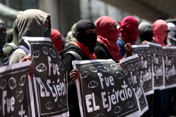 epa10202603 Demonstrators hold signs reading &#039;It was the army&#039; during a protest for the 43 disappeared students of Ayotzinapa, in Mexico City, Mexico, 23 September 2022. The demonstrators ma ...