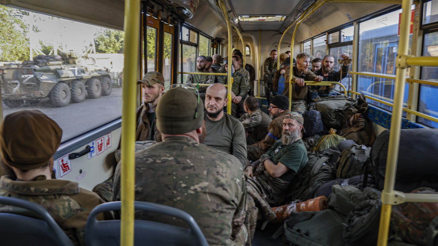 epa09953827 Ukrainian servicemen sitting in a bus as they are being evacuated from the besieged Azovstal steel plant in Mariupol, Ukraine, 17 May 2022. A total of 265 Ukrainian militants, including 51 ...