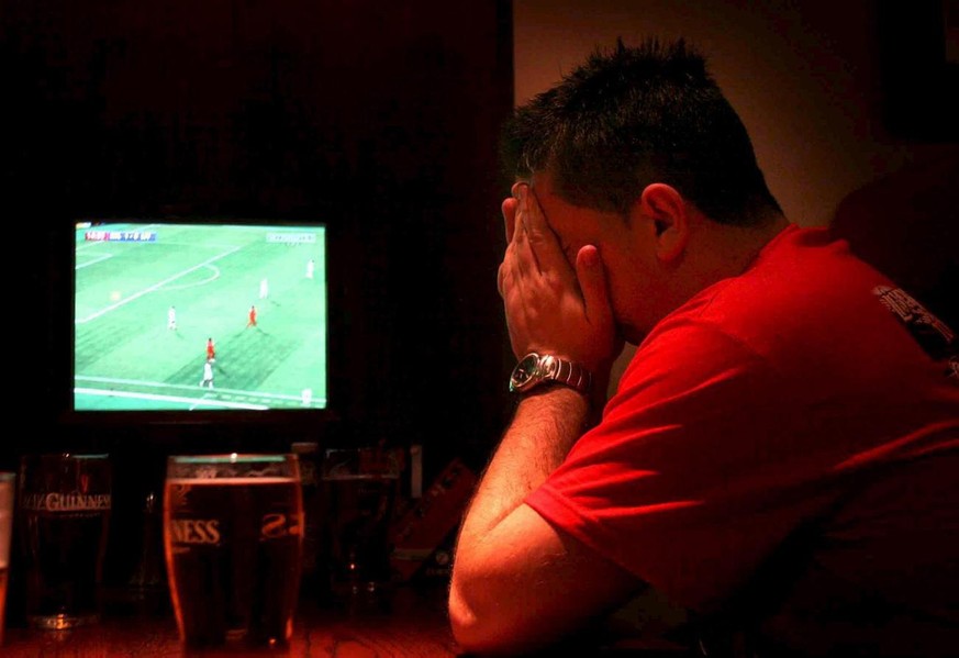 An England Liverpool fan watches TV in a pub, in Liverpool, north west England, and hold his head in his hands as Hernan Crespo scores the third goal for AC Milan against LIverpool during the UEFA Cha ...