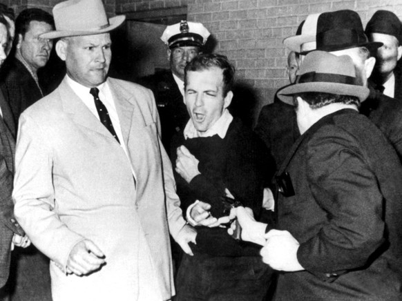 Arr�t� peu apr�s les coups de feu, l&#039;assassin pr�sum�, Lee Harvey Oswald (au centre), sera abattu deux jours plus tard par Jack Ruby (� droite).