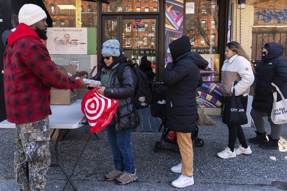 Abou Sow hands out cartons of eggs to people waiting in line to receive free eggs from FarmerJawn Agriculture, Friday, March 21, 2025, in the Harlem neighborhood of New York. (AP Photo/Julia Demaree N ...