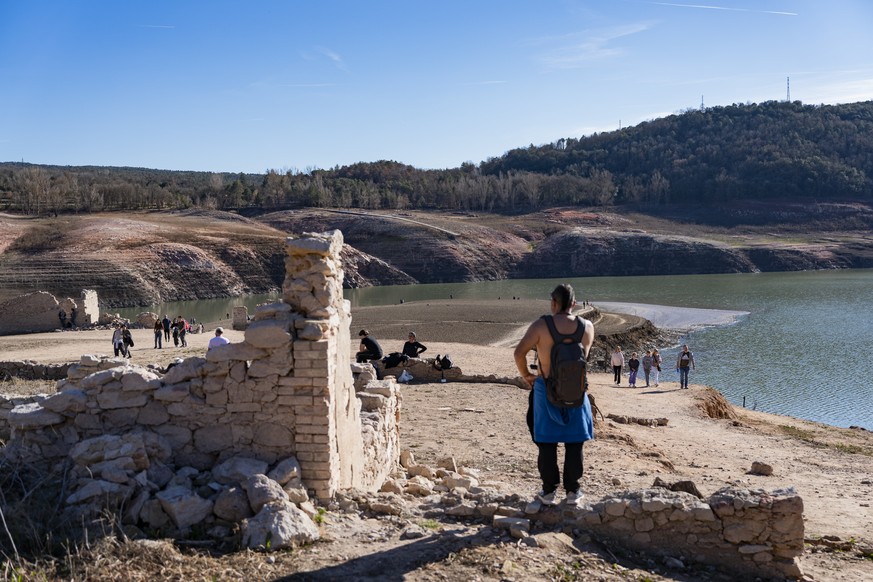 epa11126736 People visit Sau reservoir amid the declaration of emergency because of droughts, in Sau, near Barcelona, Catalonia, Spain, 04 February 2024. The ruins of the former town of Sant Roma de S ...