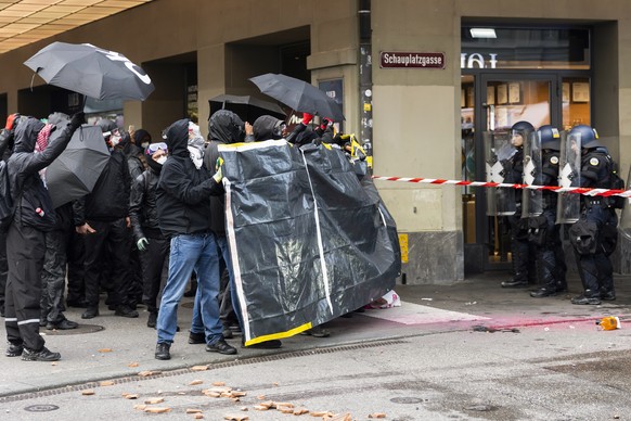 epa12447104 Protesters face police officers during an unauthorized rally in solidarity with the Palestinian people, in Bern, Switzerland, 11 October 2025. EPA/PETER KLAUNZER