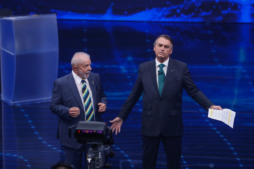 Brazil&#039;s former President Luiz Inacio Lula da Silva, who is running for office again, left, faces Jair Bolsonaro in a presidential debate at Bandeirantes Television in Sao Paulo, Brazil, Sunday,  ...