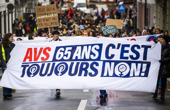 Des personnes manifestent avec une banderole &quot;AVS 65 ans c&#039;est toujours non&quot; pour reclamer une reduction du temps de travail, lors de la journee d&#039;action nationale de la Greve pour ...