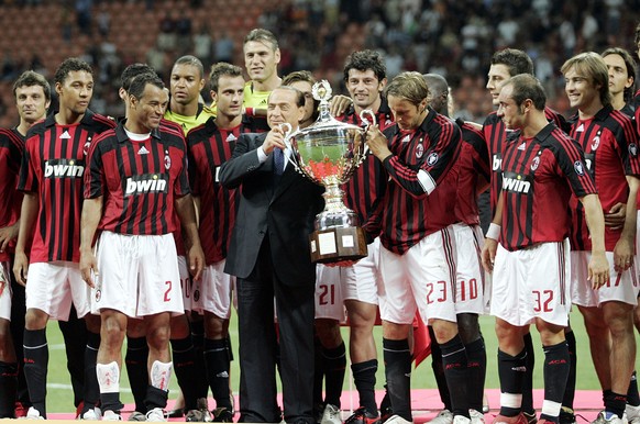 FILE - AC Milan president Silvio Berlusconi, center in dark suit, celebrates with the team after defeating Juventus to win the Luigi Berlusconi Trophy exhibition soccer match at the San Siro stadium i ...