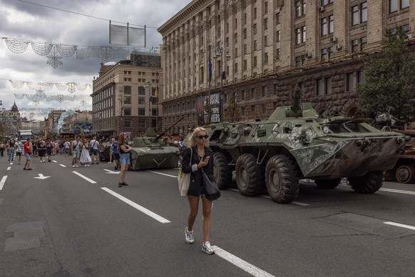 epa10130458 People pass Russian armoured military vehicles that were destroyed in fights with the Ukrainian army, displayed on Khreshchatyk street, in downtown Kyiv, ahead of the &#039;Independence Da ...