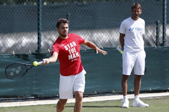 Stan Wawrinka of Switzerland in action beside his coach Yannick Fattebert during a training session at the All England Lawn Tennis Championships in Wimbledon, London, Sunday, July 1, 2018. The Wimbled ...