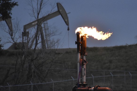 FILE - A flare burns at a well pad Aug. 26, 2021, near Watford City, N.D. American oil and natural gas wells, pipelines and compressors are spewing three times the amount of the potent heat-trapping g ...