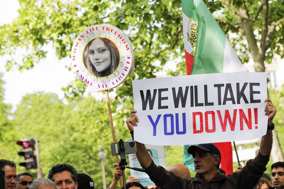 epa10648555 People hold up banner and a portrait of Mahsa Amini (C), who died in detention following her arrest by the Iranian morality police in September 2022, as they take a demonstration a demonst ...