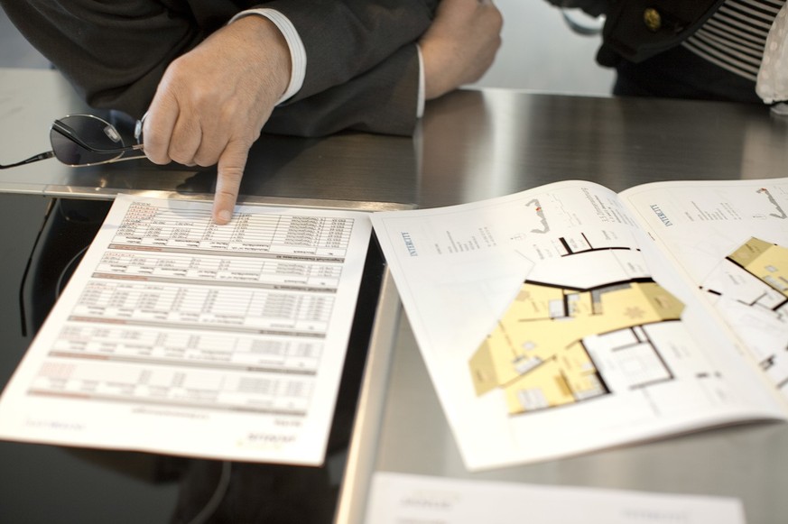 A prospective client compares the surface areas of the different apartments on offer during the viewing of a sample apartment in a new building in Basel, Switzerland, on March 24, 2010. (KEYSTONE/Mart ...