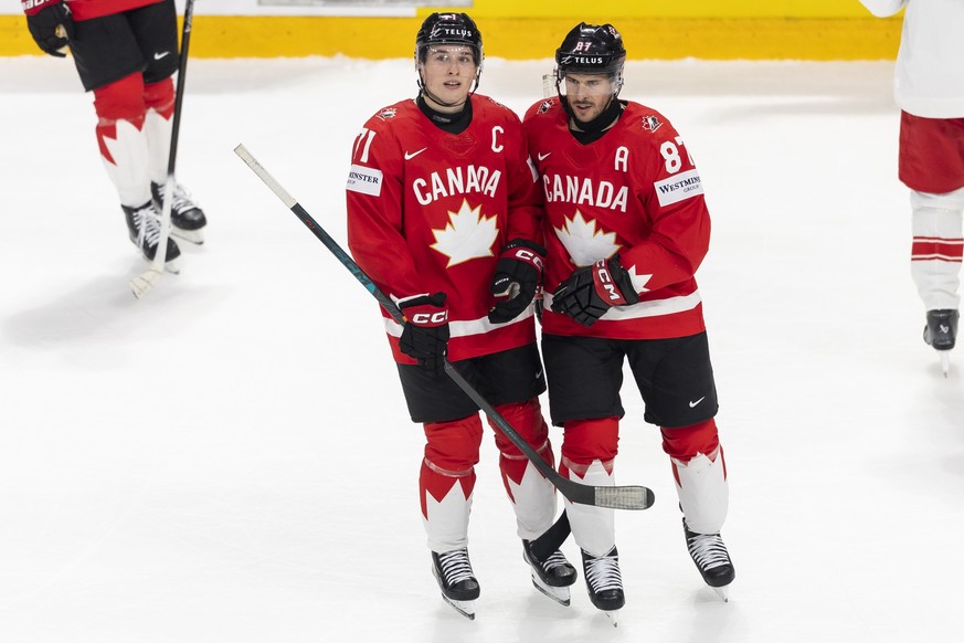 Canada's Macklin Celebrini, left, and Canada's Sidney Crosby, right, react during the 2026 IIHF Men's Ice Hockey World Championship preliminary round group B game between Canada and Den ...