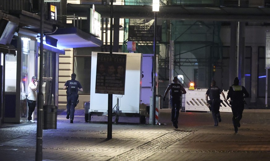 epa11563698 Police forces run on a street in Solingen, Germany, 24 August 2024. A man stabbed passers-by at random with a knife during the city festival in Solingen late 23 August. Three people have b ...