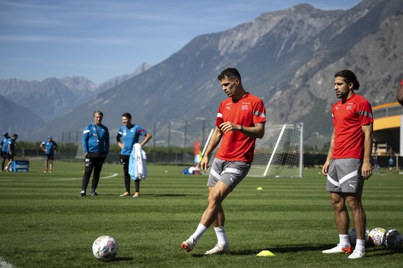 Switzerland&#039;s national soccer team head coach Murat Yakin, behind left, and his assistant Vincent Cavin, behind right, looking at they players Granit Xhaka, second from right, and Ricardo Rodrigu ...