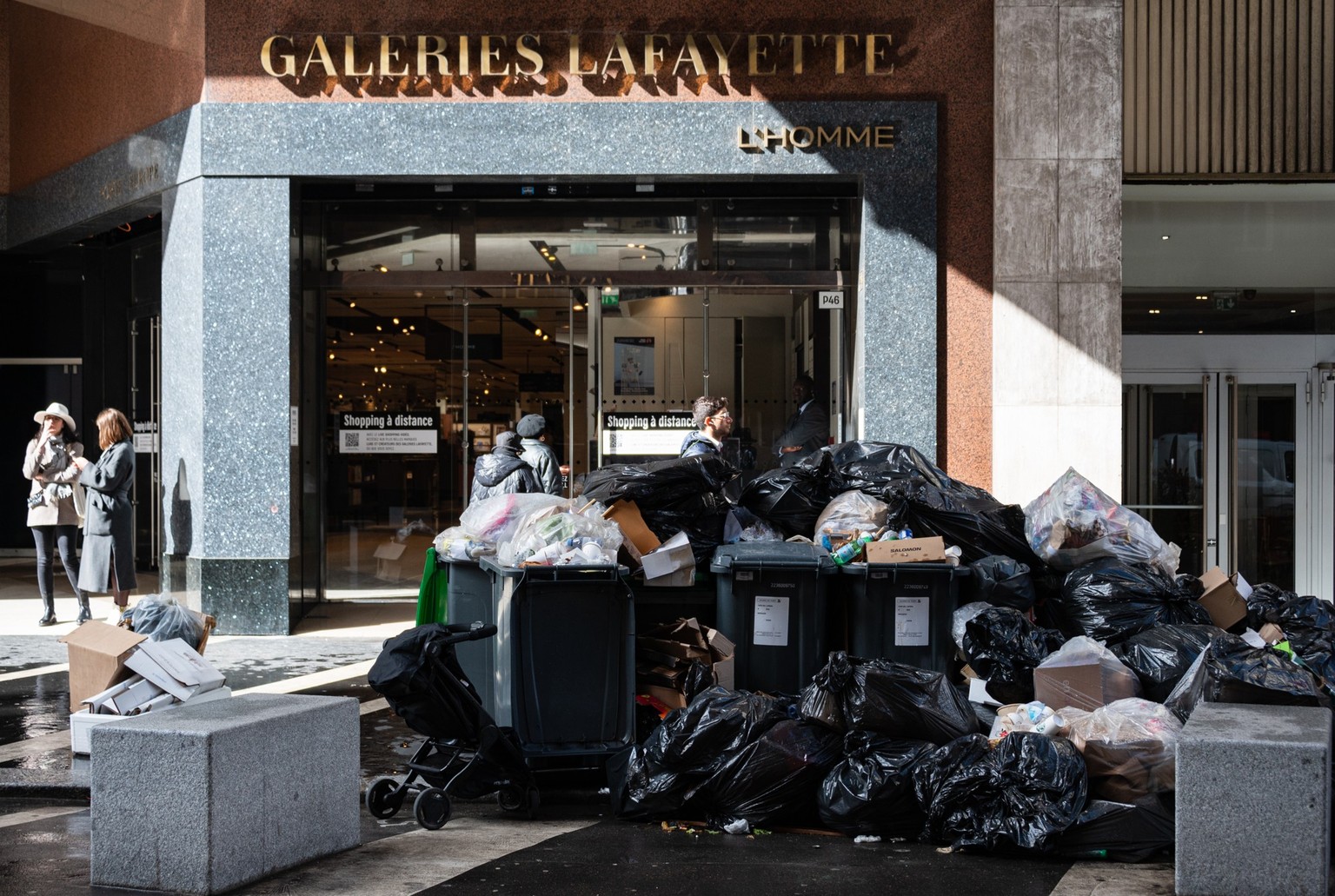 Household waste containers and rubbish dumps pile up on the pavement in front of Galeries Lafayette in Paris on March 14, 2023 since garbage collectors went on strike against the French government&#03 ...