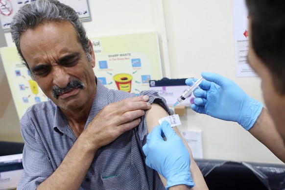 epa09282860 A Palestinian medical worker receives a COVID-19 vaccine at the Palestinian Red Crescent Hospital in the West Bank city of Hebron, 18 June 2021. The Israeli government on 18 June said it agreed on a deal with the Palestinian Authority (PA) according to which Israel will transfer between 1 million and 1.4 million doses of the Pfizer coronavirus vaccine presently in stock in Israel that will expire soon to the PA. In return, Israel will receive an identical quantity of new vaccine doses from Pfizer during September and October 2021. EPA/ABED AL HASHLAMOUN