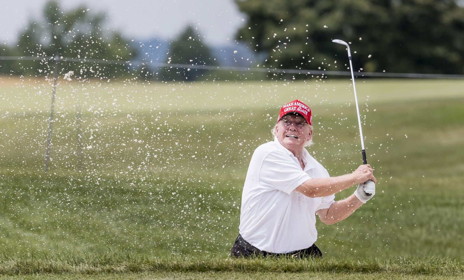 epa10096122 Former US President Donald J. Trump hitting out of the sand on the 15th green during a Pro-Am tournament leading up to the LIV Golf Bedminster invitational, part of the new LIV Golf Invita ...