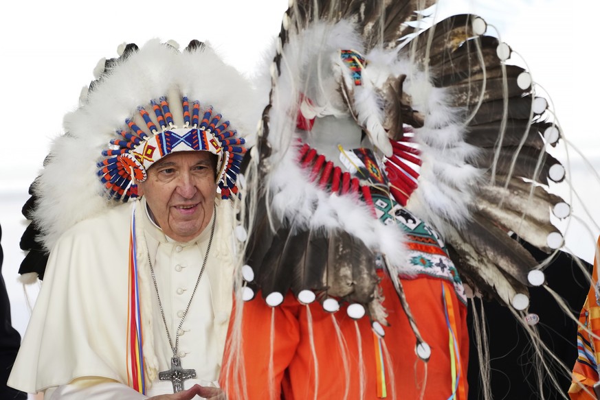 Pope Francis, left, wears a traditional headdress he was given after his apology to Indigenous people during a ceremony in Maskwacis, Alberta, as part of his papal visit across Canada, Monday, July 25 ...