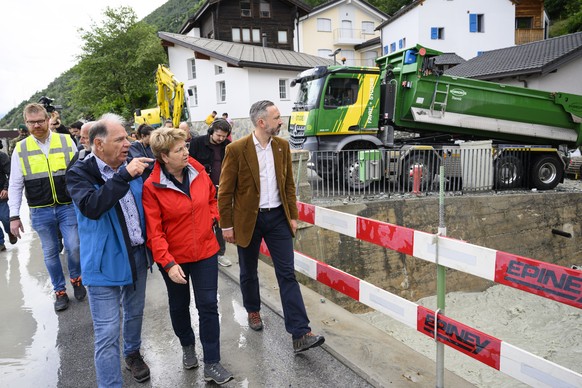 epa11449421 Swiss Federal President Viola Amherd (C) and Frederic Favre, State Councillor of the Canton of Valais (R), visit regions hit by bad weather, in Chippis, Switzerland, 01 July 2024. Severe s ...