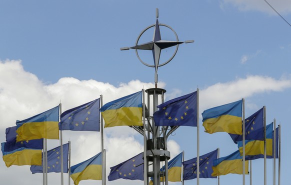 epa10741816 Ukraine&#039;s national flags and EU flags fly under the NATO logo in European Square, downton Kyiv (Kiev), Ukraine, 12 July 2023, amid the Russian invasion. The NATO logo was installed in ...