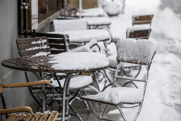 Der Schneefall bringt den Winter zurueck, wie hier bei einem Restaurant in Engelberg im Kanton Obwalden auf 1000 Meter ueber Meer am Donnerstag, 18. April 2024. (KEYSTONE/Urs Flueeler)