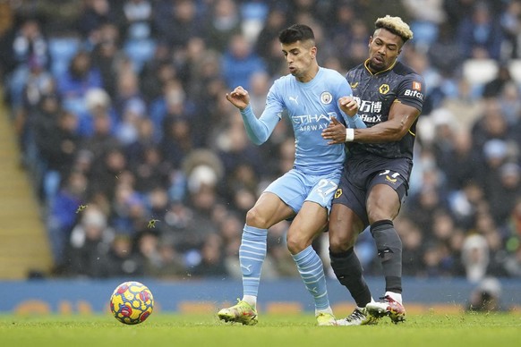 Manchester City&#039;s Joao Cancelo, left, challenges for the ball with Wolverhampton Wanderers&#039; Adama Traore during the English Premier League soccer match between Manchester City and Wolverhamp ...