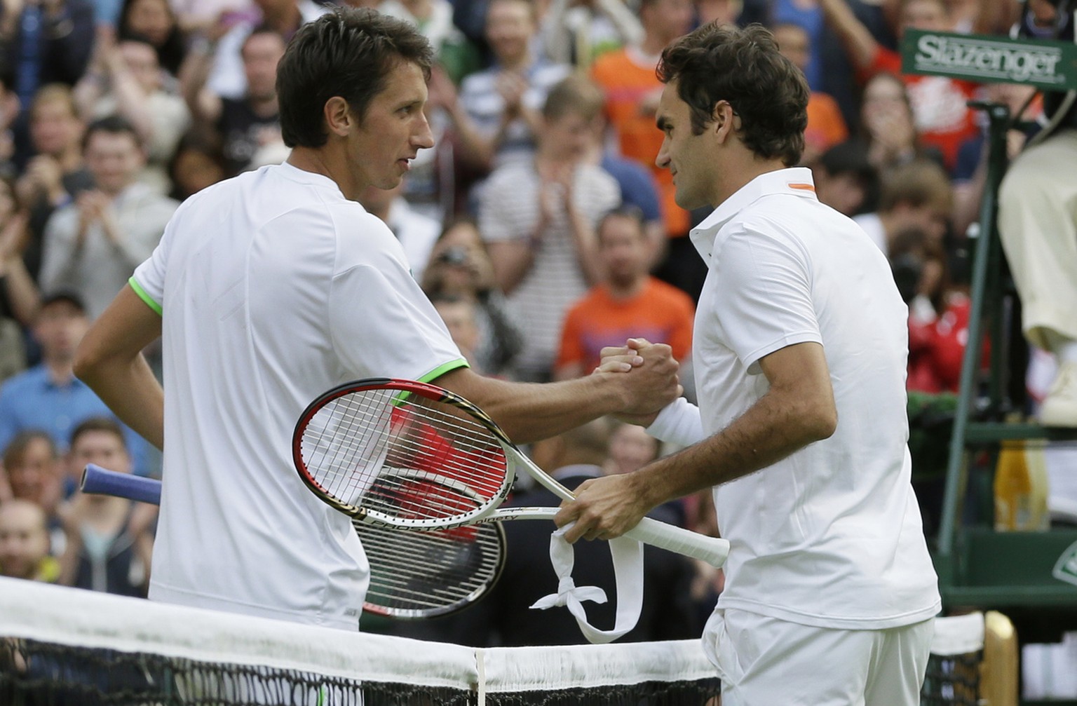 Sergiy Stakhovsky of Ukraine, left, shakes hands with Roger Federer of Switzerland after he defeated him in their Men&#039;s second round singles match at the All England Lawn Tennis Championships in  ...