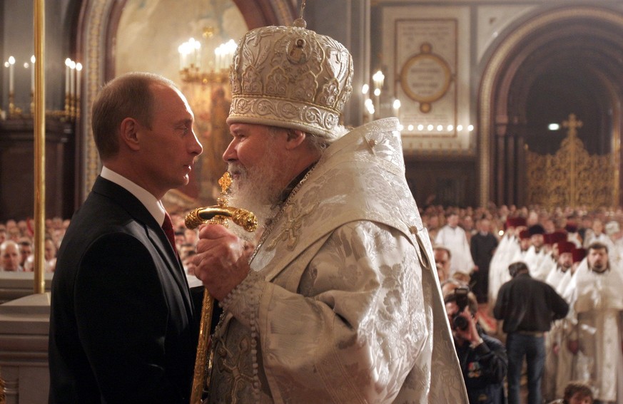 President Vladimir Putin, left, listens to Russian Orthodox Patriarch Alexy II during Easter service in the Christ the Savior Cathedral in Moscow, early Sunday, April 23, 2006. Eastern Orthodox church ...