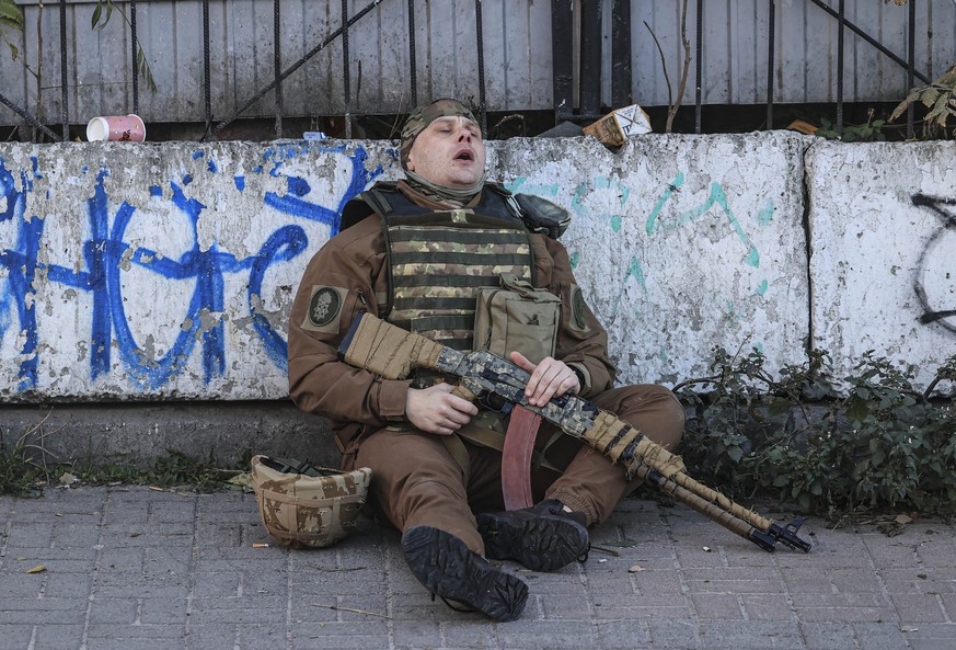 KYIV, UKRAINE - OCTOBER 17: A Ukrainian soldier rests on the sidewalk after the Russian attacks in Kyiv, Ukraine on October 17, 2022. It was reported that two separate explosions occurred in Kyiv due ...