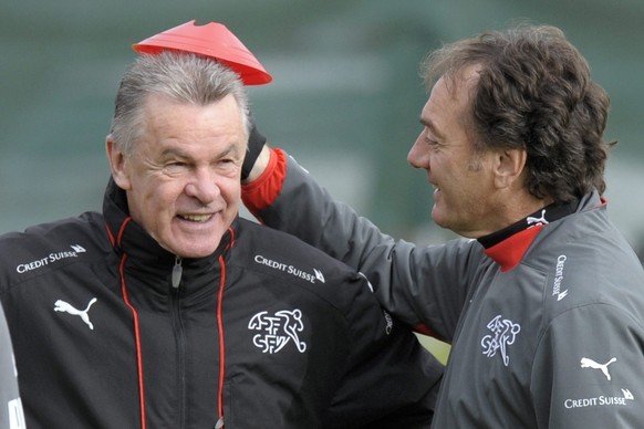 Swiss national soccer team head coach, German Ottmar Hitzfeld, left, jokes with his assistant Michel Pont, droite, during a training session at the Stadium of Arberes in Meyrin near Geneva, Switzerlan ...