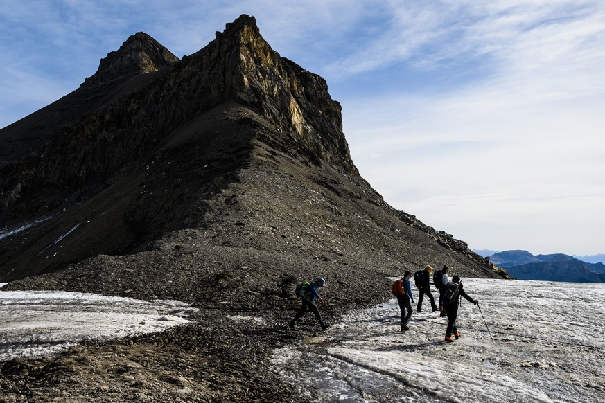 Des randonneurs marchent devant la separation du glacier du Scex Rouge avec le glacier de Tsanfleuron laissant apparaitre le col de Tsanfleuron le mardi 13 septembre 2022 sur le domaine de Glacier 300 ...