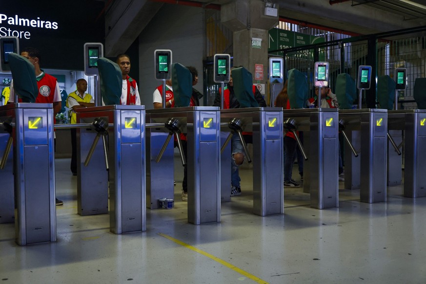 Security personnel stands at the entrance for fans with facial recognition system, at the Allianz Parque stadium in Sao Paulo, Brazil on October 11, 2025. Facial recognition technology identifies and  ...