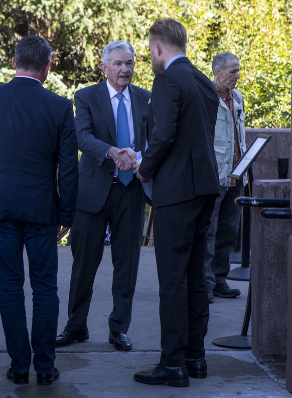 Federal Reserve Chair Jerome Powell, center, shakes hands with Asgeir Jonsson, governor of the Central Bank of Iceland at the annual Jackson Hole Economic Policy symposium at Jackson Lake Lodge in Gra ...