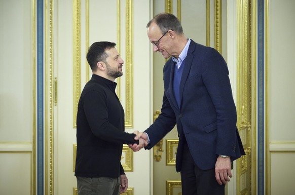 epa11766519 A handout photo made available by the Presidential Press Service of Ukraine shows Ukrainian President Volodymyr Zelensky (L) shaking hands with Friedrich Merz (R), Chairman of Germany?s Ch ...