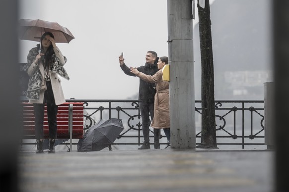 Einige Leute mit Regenschirm trotzen dem ergiebigen Regen und trueben Wetter in Lugano am Sonntag, 31. Maerz 2024. Aus touristischer Sicht sind die Ostertage 2024 im Tessin und weiteren Teilen der Sue ...