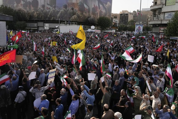 Protesters chant slogans in a protest following the U.S. attacks on nuclear sites in Iran, as an anti-Israeli banner depicting Iranian soldiers heading to attack Israeli territory is seen in backgroun ...