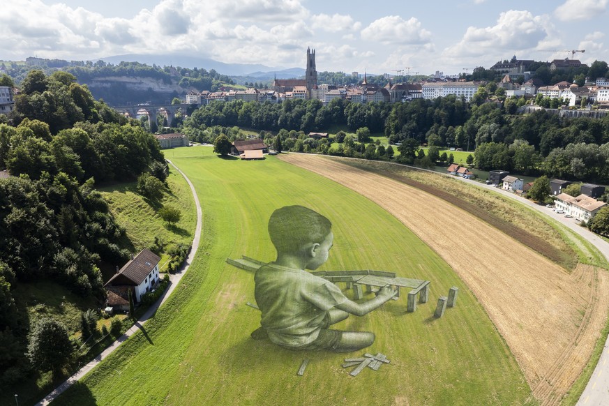 epa11551224 A picture taken with a drone shows a giant biodegradable land art painting titled &#039;Bridges?&#039; by French-Swiss artist Saype to celebrate 125th anniversary of Fribourg Tourism at th ...
