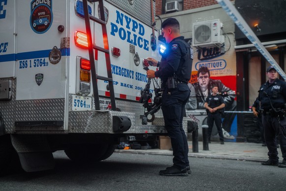 epa13175086 A New York City Police Department (NYPD) officer holds a gun belt at the scene of a police-involved shooting in New York, New York, USA, 16 August 2026. At least six people, including four ...