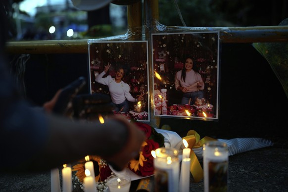 A person lights a candle at a makeshift memorial outside the Jet Set nightclub, in memory of the more than 200 people who died when its roof collapsed, in Santo Domingo, Dominican Republic, Friday, Ap ...
