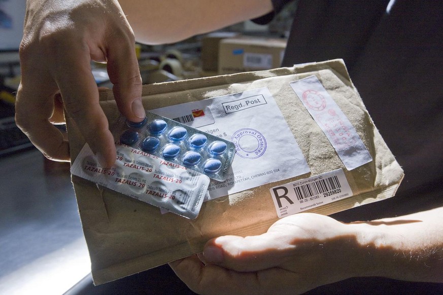 Un employé de la douane de Zurich montre un colis contenant de fausses pilules de Viagra.