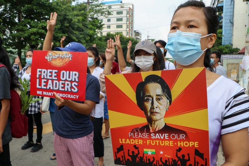 Anti-coup protesters hold a banner which reads