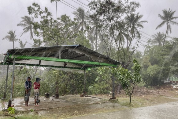 Two children stand under a roadside shelter to protect from rain before Cyclone Mocha hits in Sittwe, Rakhine State, Sunday, May 14, 2023. Bangladesh and Myanmar were bracing Sunday as the extremely s ...