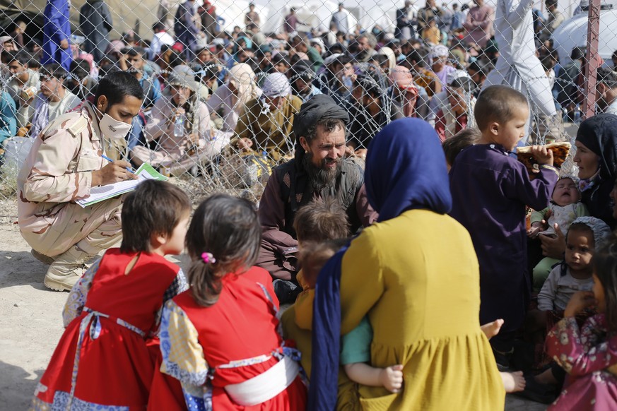 epa09420840 A handout photo made available by Iranian Red Crescent shows Afghan refugees gather in Iran-Afghanistan border in Sistan-Blochestan province, south-eastern Iran, 16 August 2021 (issued 19  ...