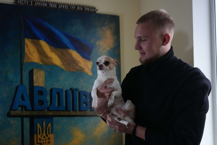 Kostiantyn Kosik pose avec un chiot dans sa chambre à Irpin (banlieu ouest de Kiev), le 20 octobre 2025.
